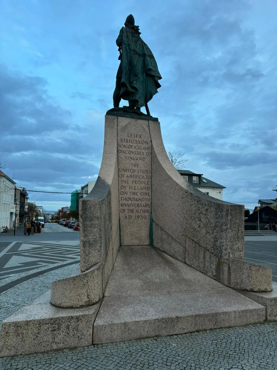 Viajero de pie en una playa de arena negra con olas rompiendo