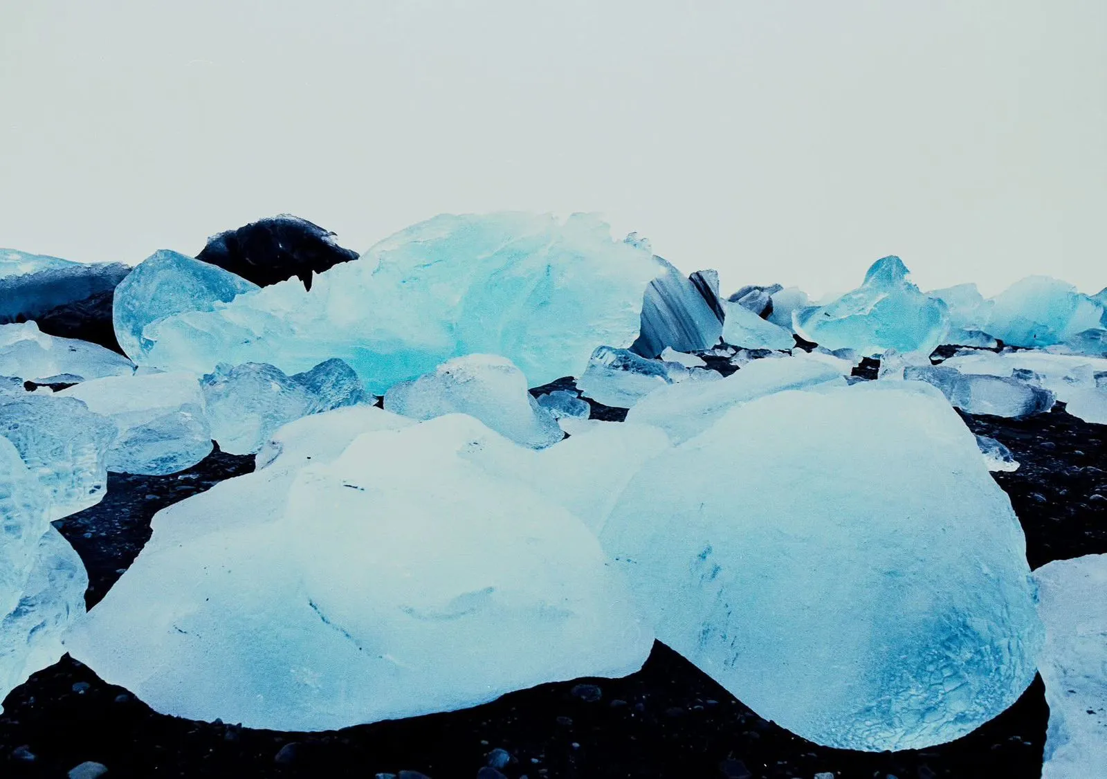 Dos viajeros sonriendo con cascos frente a una cascada helada