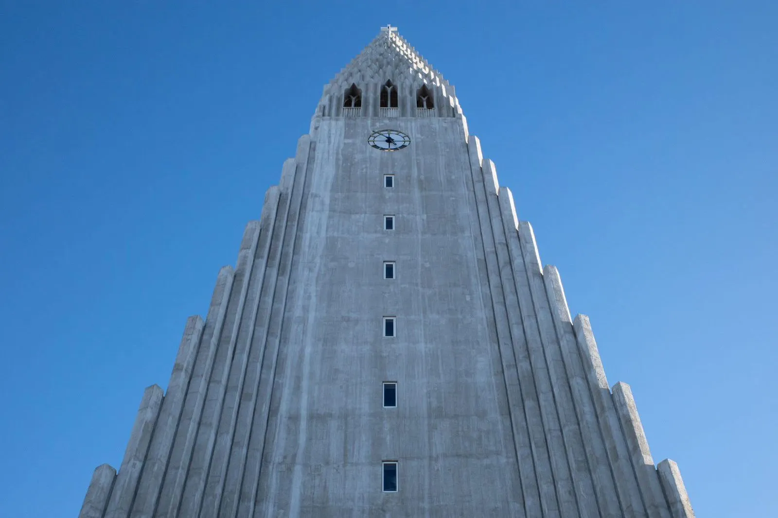 Sendero invernal con montañas y lago helado al atardecer