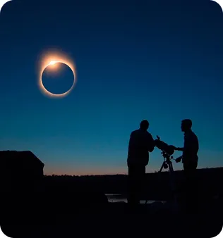 Personas contemplando un eclipse en un paisaje nevado